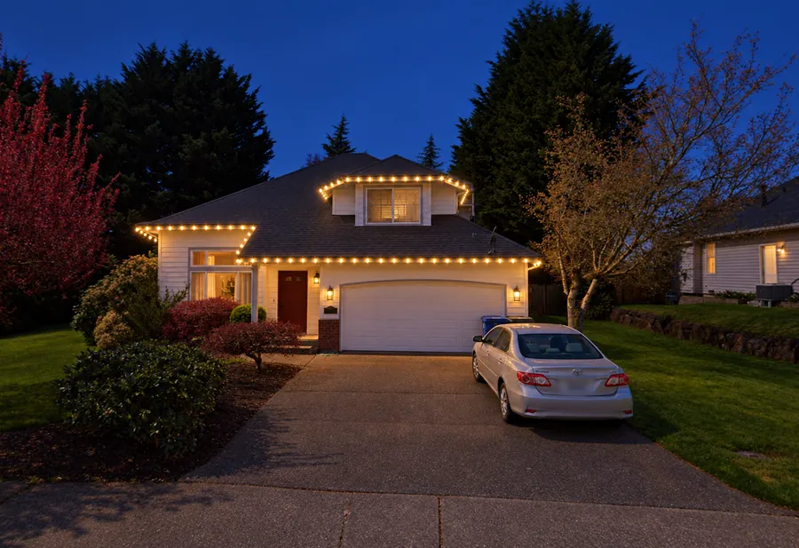 Warm-white lighting outlining garage, entrance and upper roofline on a two-story house